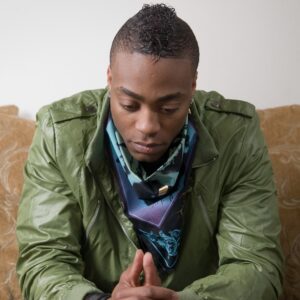 African American man in green jacket looking concerned