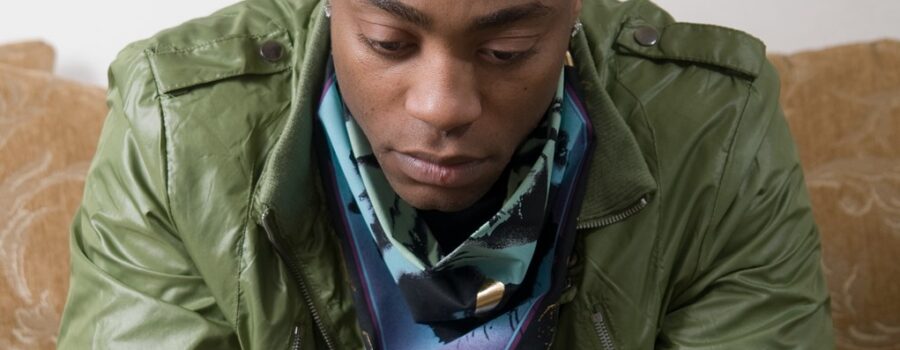 African American man in green jacket looking concerned